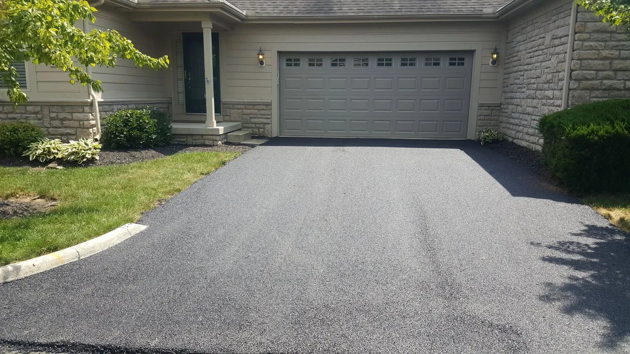 Finished asphalt driveway leading to a two-car garage