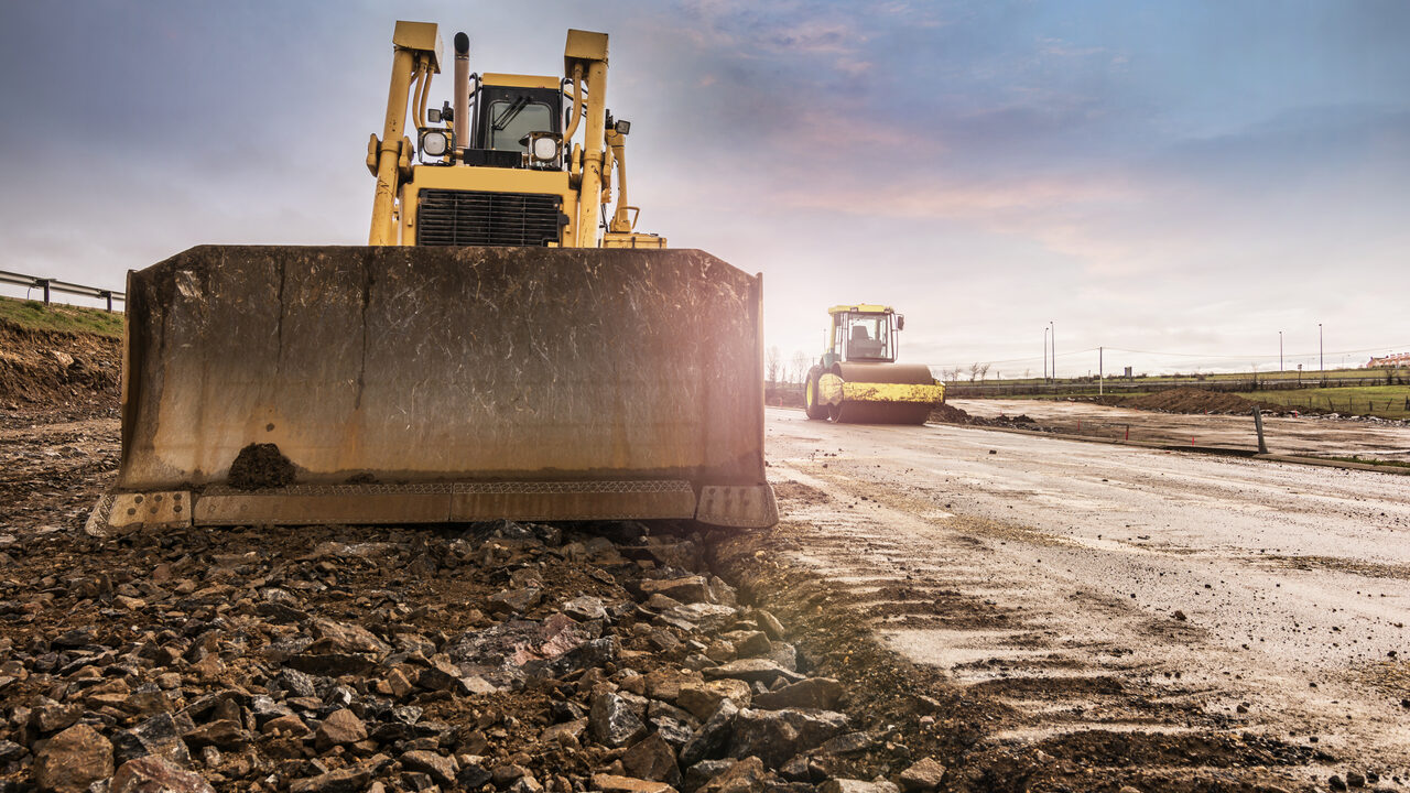 A dozer grading a road base ahead of new asphalt