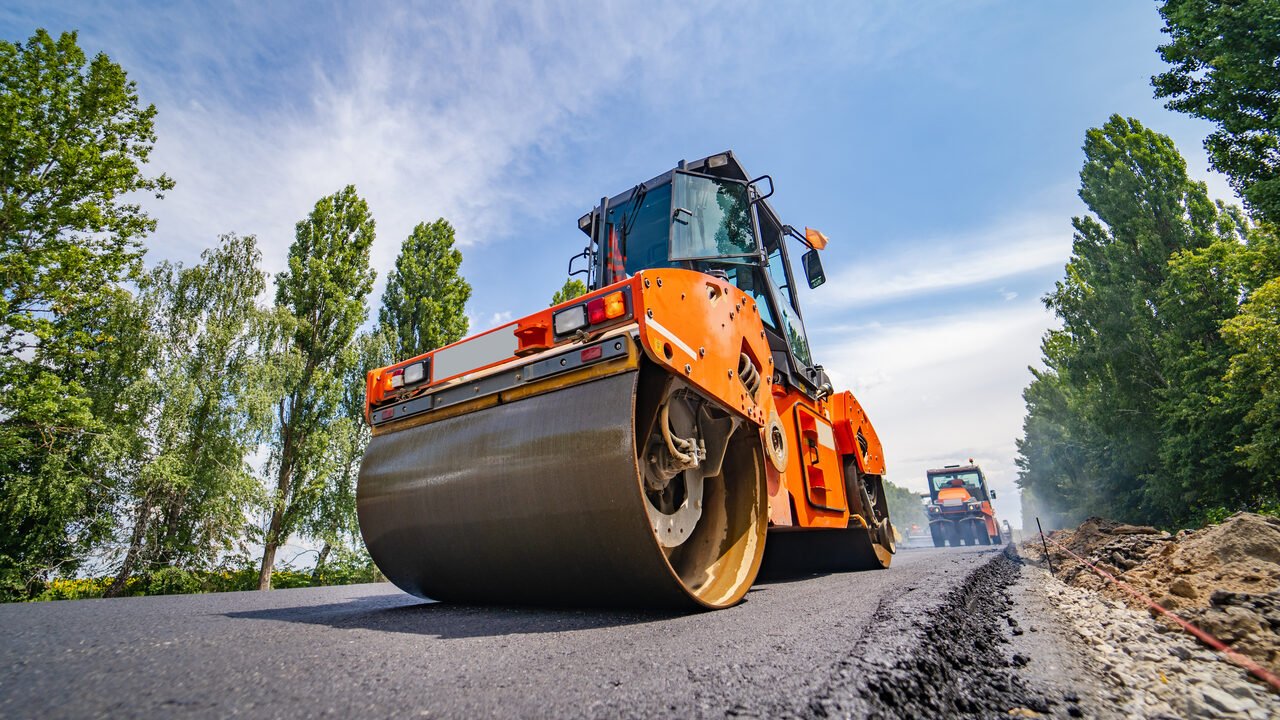 A road roller compacting a freshly laid asphalt surface